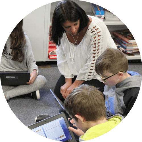 Teacher assisting students in composing letters to e-mentors