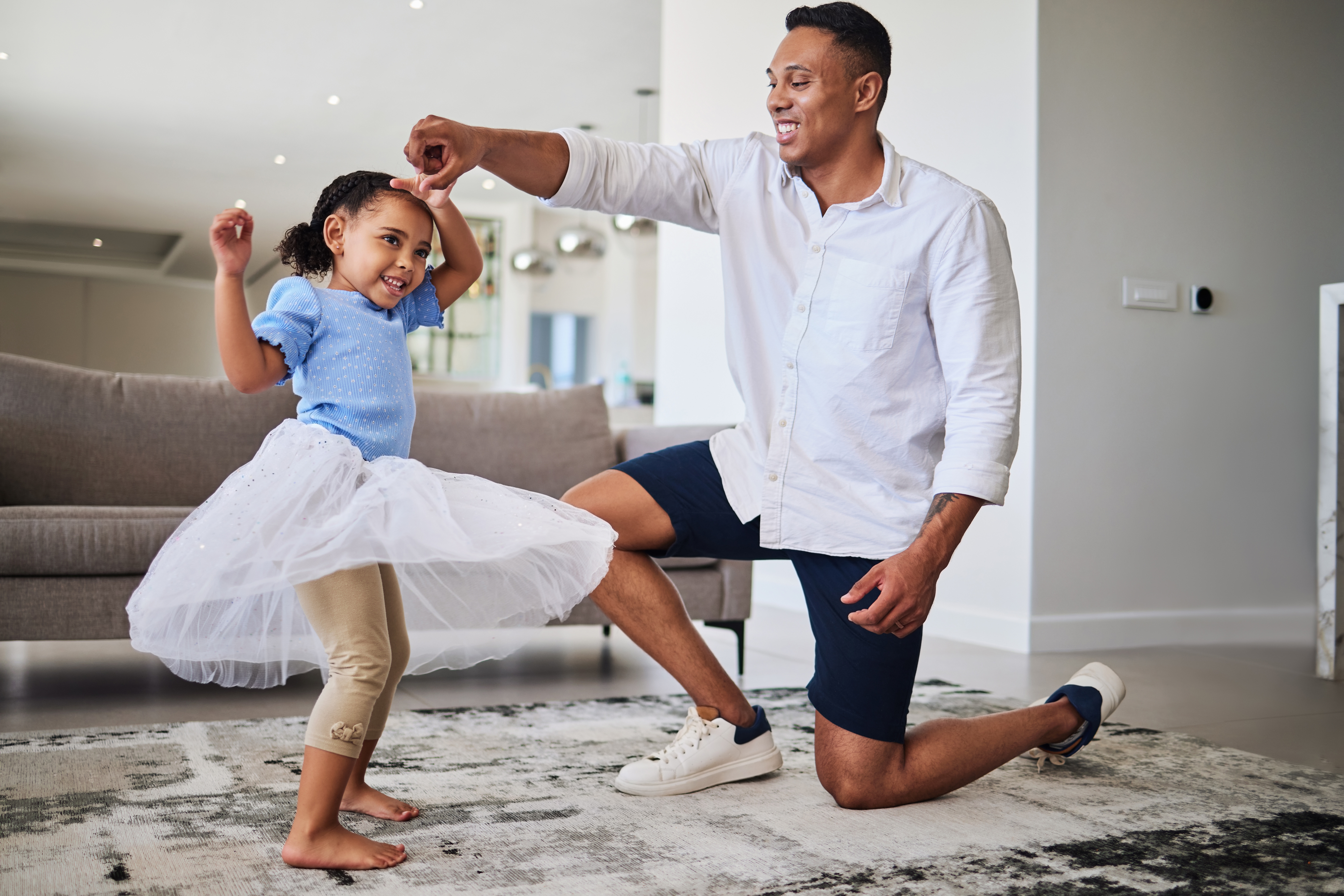 Father and young daughter dancing at home, showing how music helps children connect, move, and express themselves