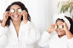Mom and daughter relaxing at home with cucumber slices on their eyes during a summer spa day