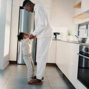 Father and daughter dance together in the kitchen as music encourages movement, self-expression, and connection.